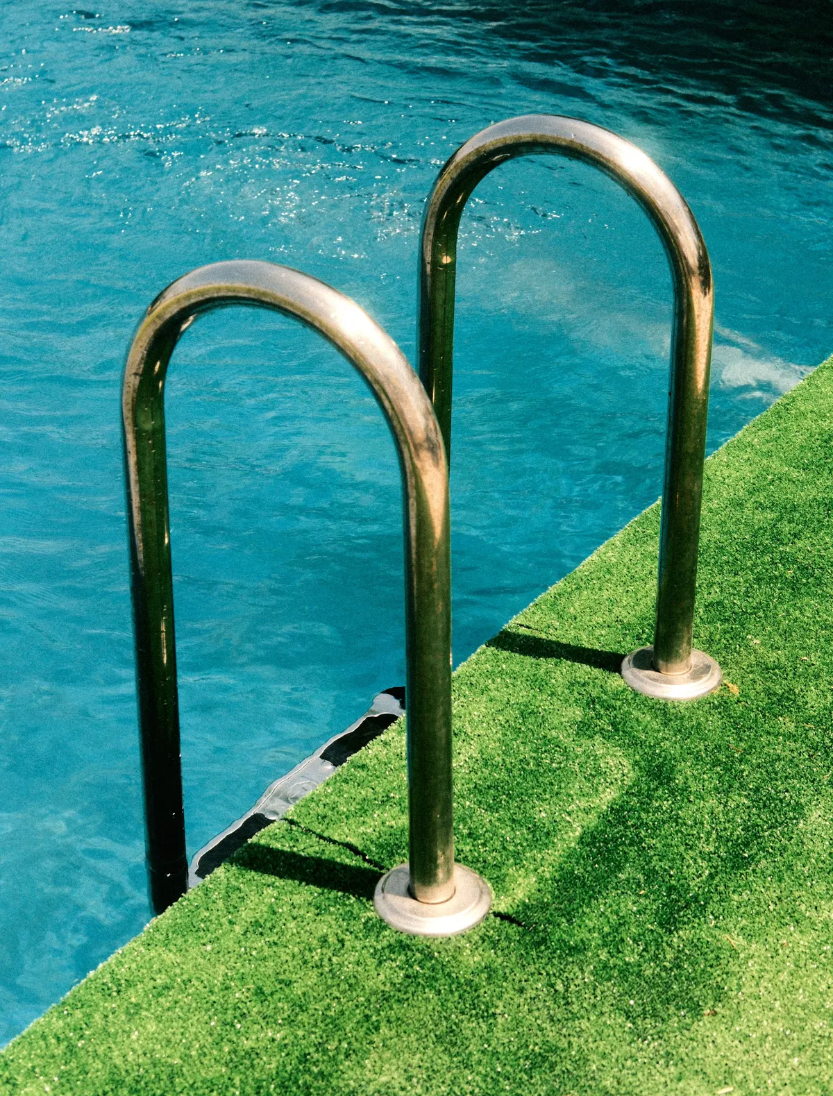 Artificial grass meeting the edge of a backyard swimming pool